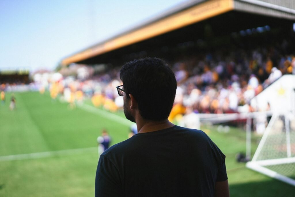 A man standing in front of a soccer field